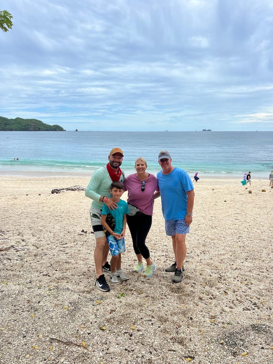 Three guests smiling on a Costa Rican beach