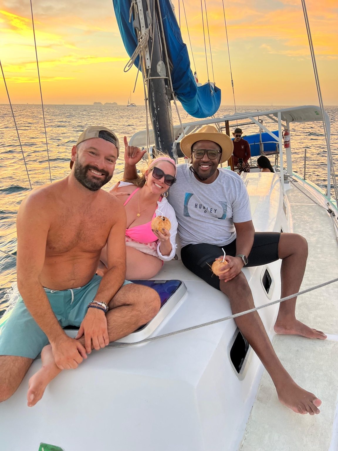 Friends enjoying the Pacific sunset on a sailboat