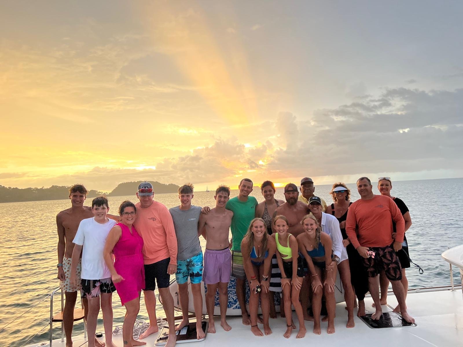 A group of guests enjoying a sunset at sea